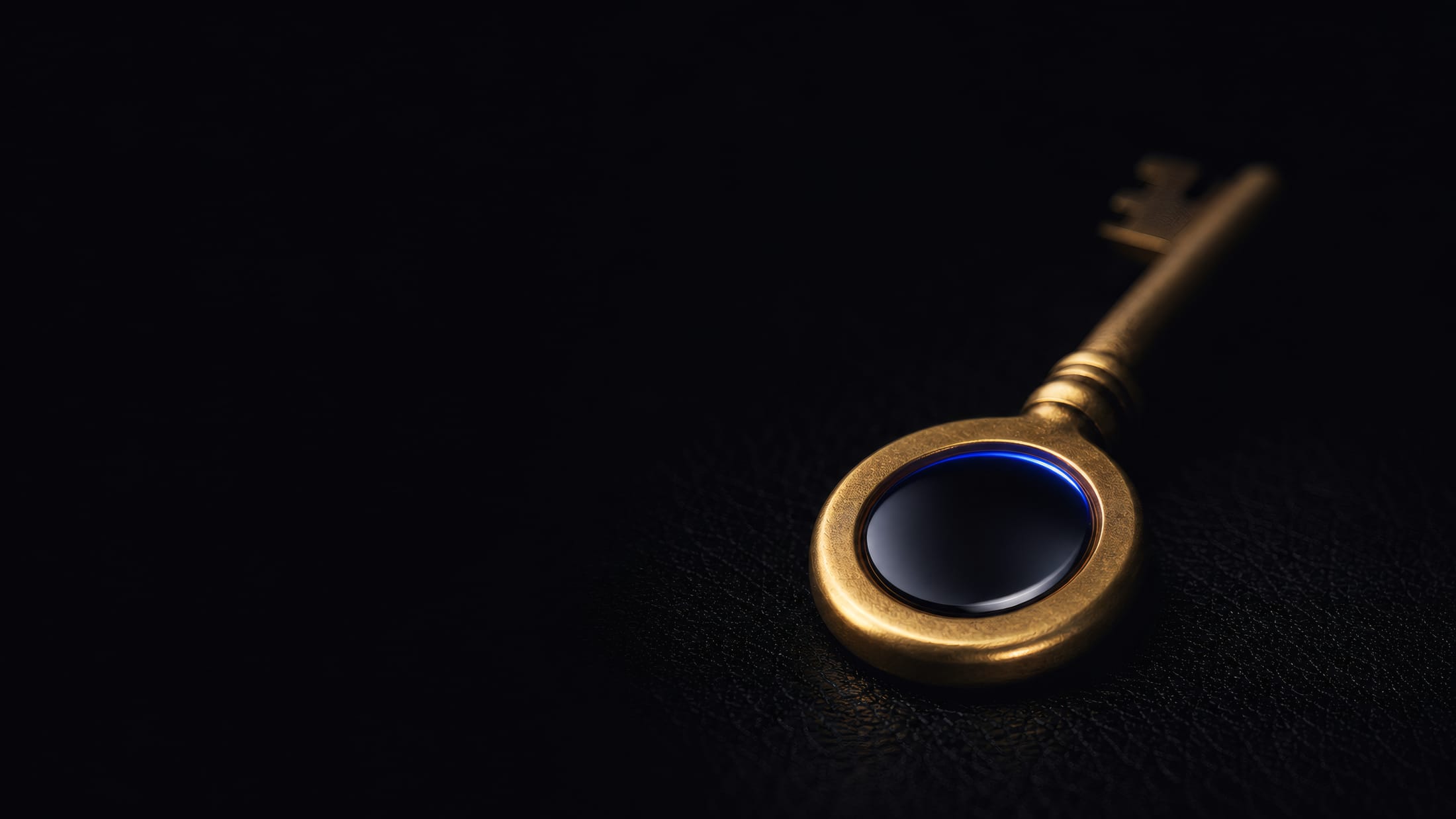 A brass key resting on a dark surface, custom-cut