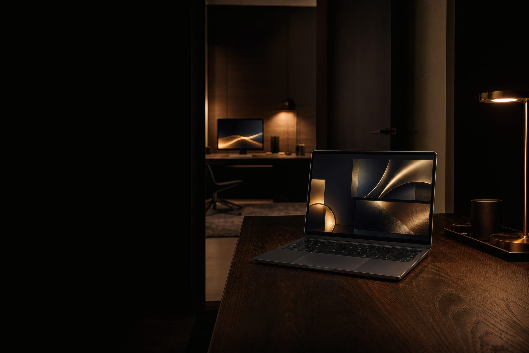 A laptop open in a quiet studio at night, its screen carrying a plain unbranded surface