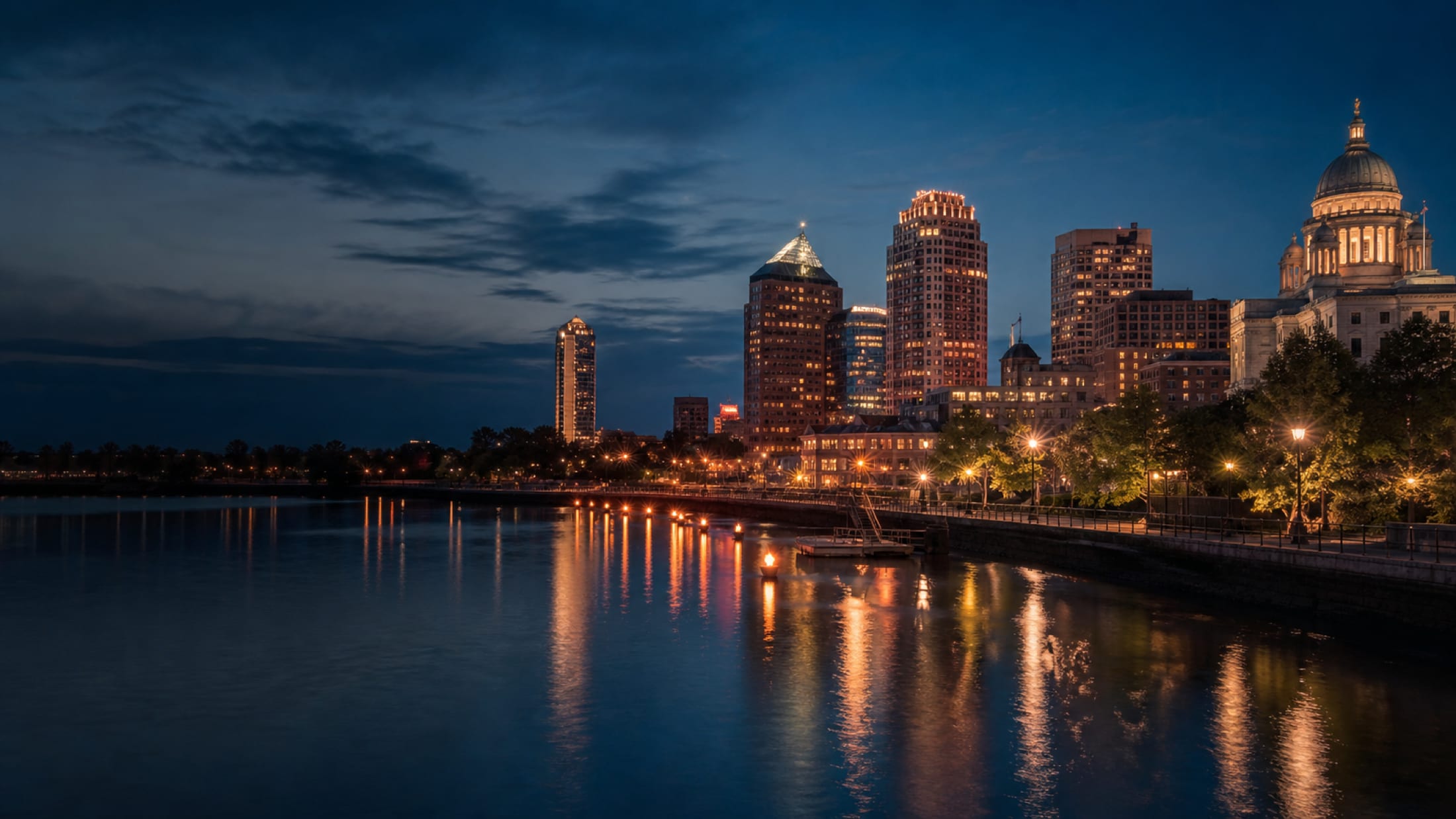 The Providence skyline at dusk across the river, downtown towers and lights on the water
